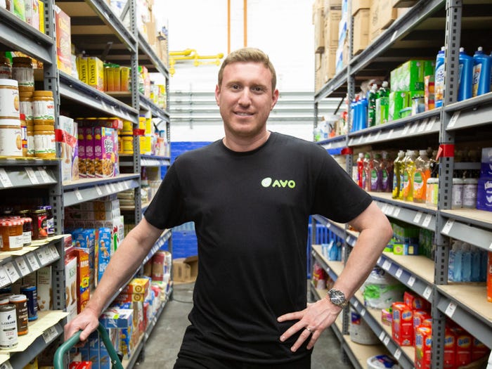 Avo CEO Dekel Valtzer standing in a warehouse aisle stocked with packaged foods