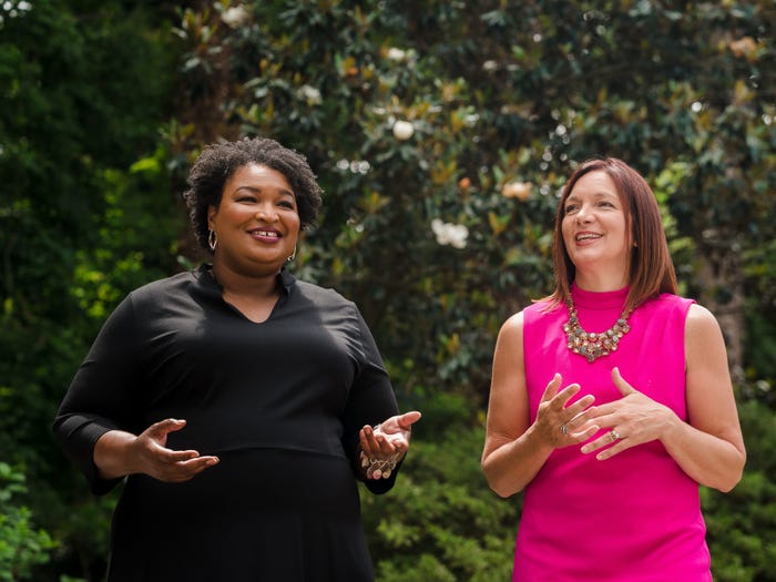 Stacey Abrams and Lara Hodgson, Now co-founders, pose outside in front of hedge