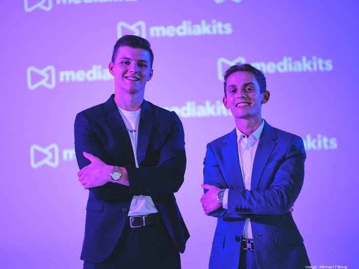 startup founders of MediaKits pose with their arms crossed in front of a glowing background