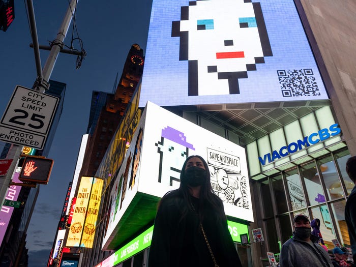 cryptopunk nfts are displayed on a billboard in new york city