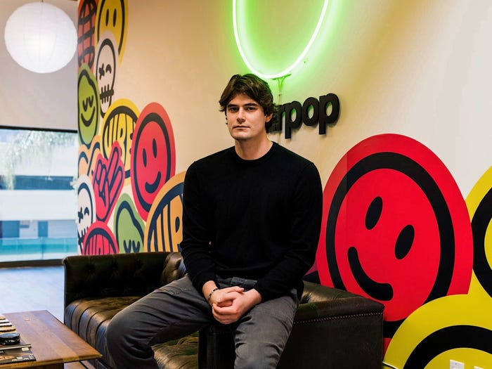 Pearpop cofounder Cole Mason poses in front of a glowing Pearpop logo.